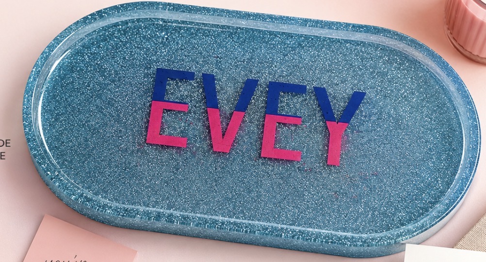 Blue glitter oval resin tray personalized with the name Evey in pink and blue lettering